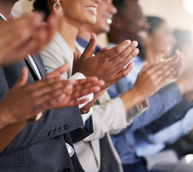 Audience applauding in formal attire.